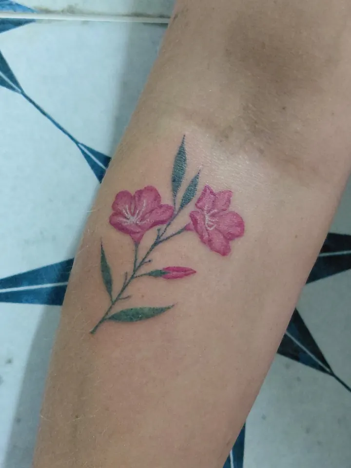 Pink flowers with green leaves on the forearm