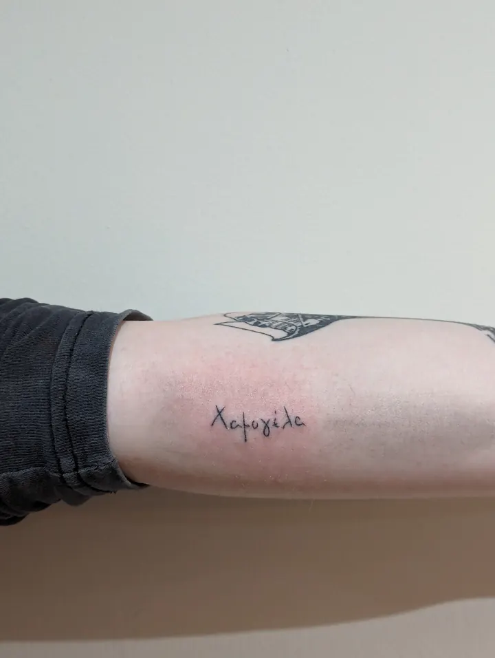 Handwritten Greek word on the forearm