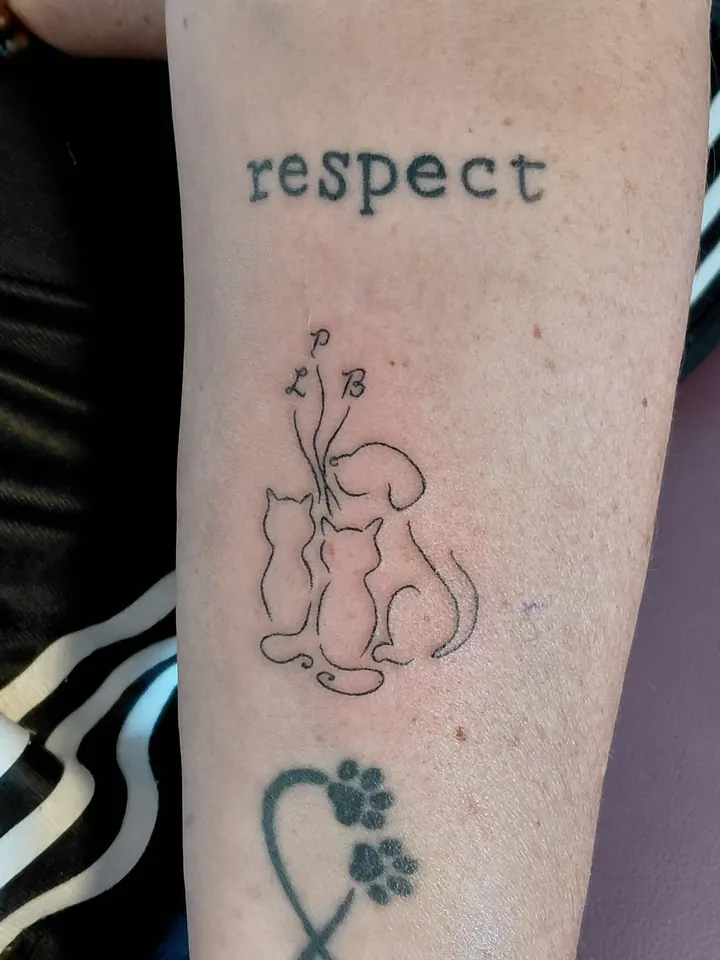 Line drawing of cats and a dog on the forearm